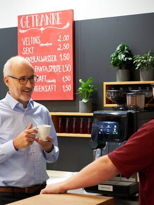 Service Techniker erklärt Kunden den Kaffeeautomaten
