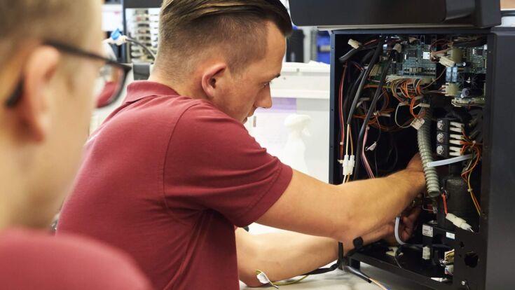 Techniker von Kaffee Partner repariert Kaffeevollautomaten